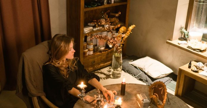 Signs You May Have Psychic Abilities Woman reflecting over tarot cards in a calm spiritual setting