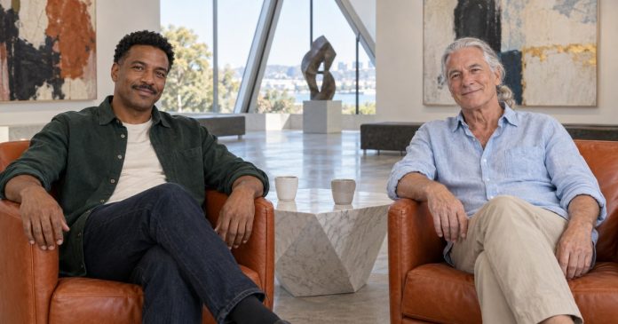 Adult relationships at different life stages Two mature men seated in separate chairs in a bright gallery lobby
