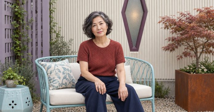 Caring Without Carrying Every Feeling Mature woman pausing comfortably on a garden seat in a quiet courtyard.