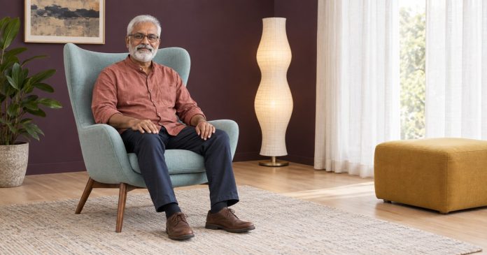 Mature man seated comfortably with relaxed hands in a quiet contemporary room