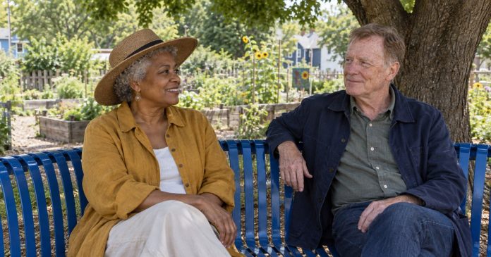 Two mature friends sharing a shaded break on a curved park bench