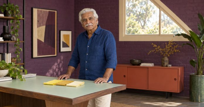 Yellow Symbolism and Personal Meaning Mature man considering yellow fabric samples in a colorful personal workspace.